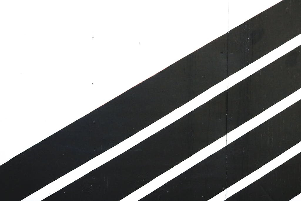 Dynamic black and white diagonal stripes create a modern contrast in this minimalist abstract art.